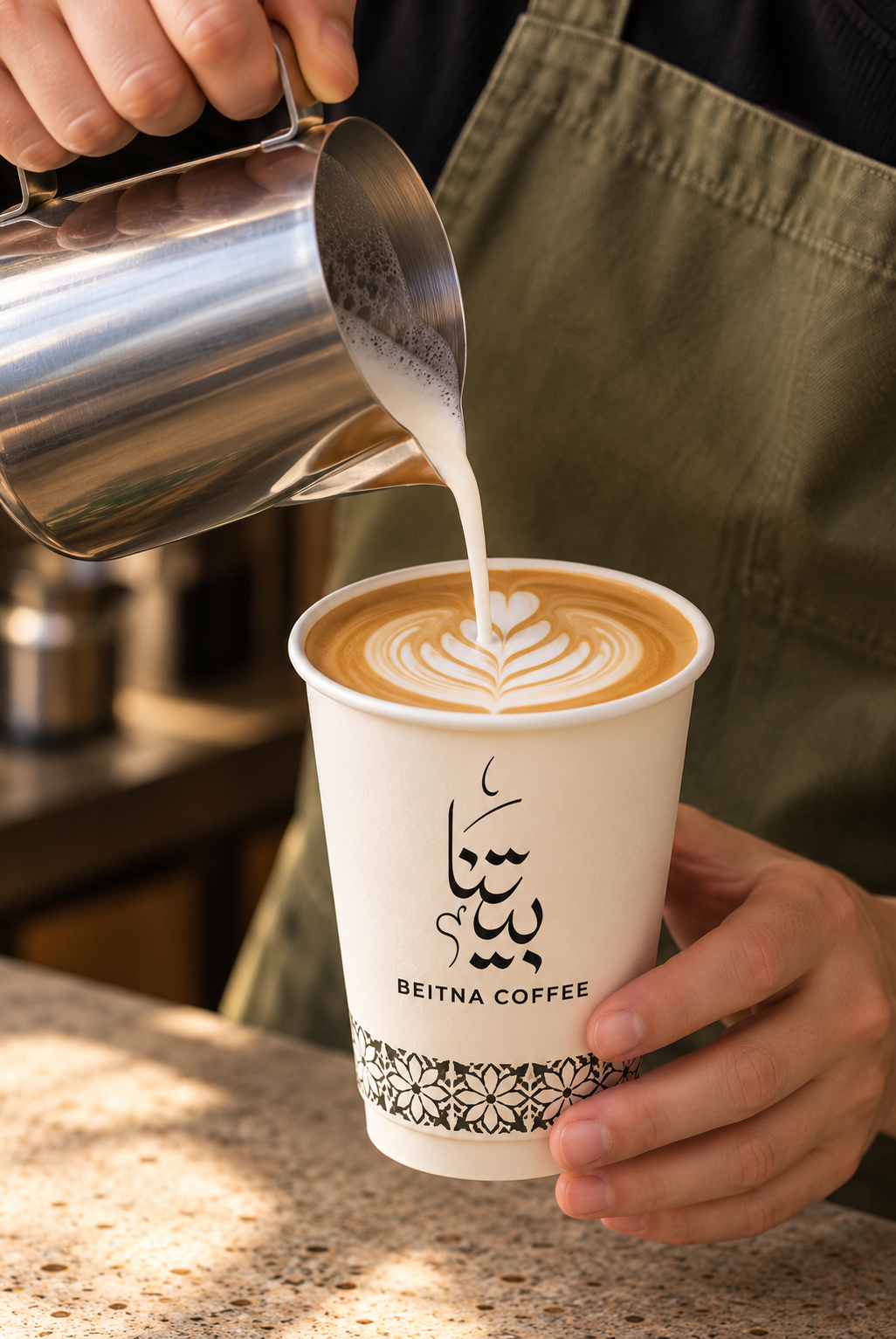 Latte art being poured into a cream Beitna cup