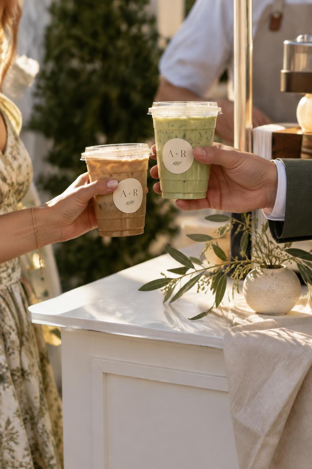 Wedding guests holding iced drinks with A and R monogram cup stickers